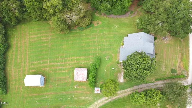 a view of a house with a yard and a large tree