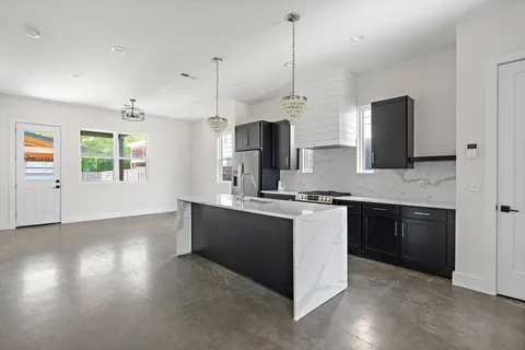 a kitchen with stainless steel appliances granite countertop a stove a sink and a refrigerator