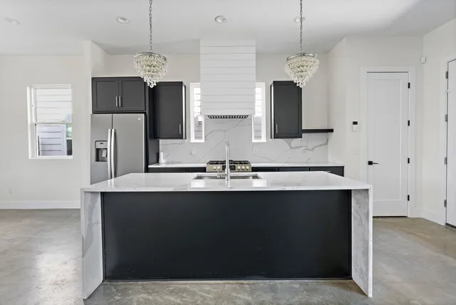 a view of a kitchen with a sink and dishwasher with wooden floor