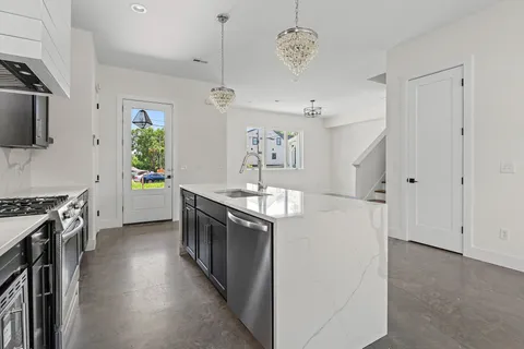 an open kitchen with a sink a stove oven and a window