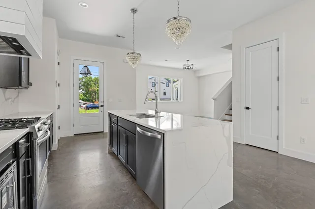 an open kitchen with a sink a stove oven and a window