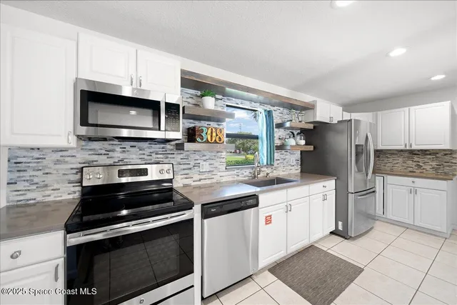 a kitchen with stainless steel appliances granite countertop a stove microwave and cabinets