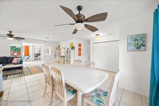 a view of a dining room with furniture and a chandelier fan