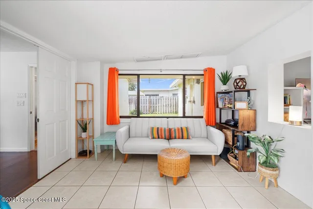 a living room with furniture a window and a potted plant