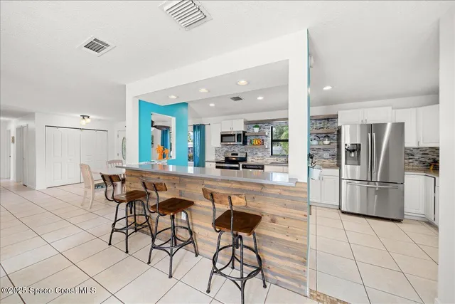 a kitchen with stainless steel appliances kitchen island granite countertop a refrigerator and cabinets