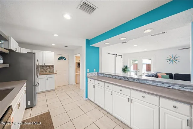 a kitchen with granite countertop white cabinets and white appliances