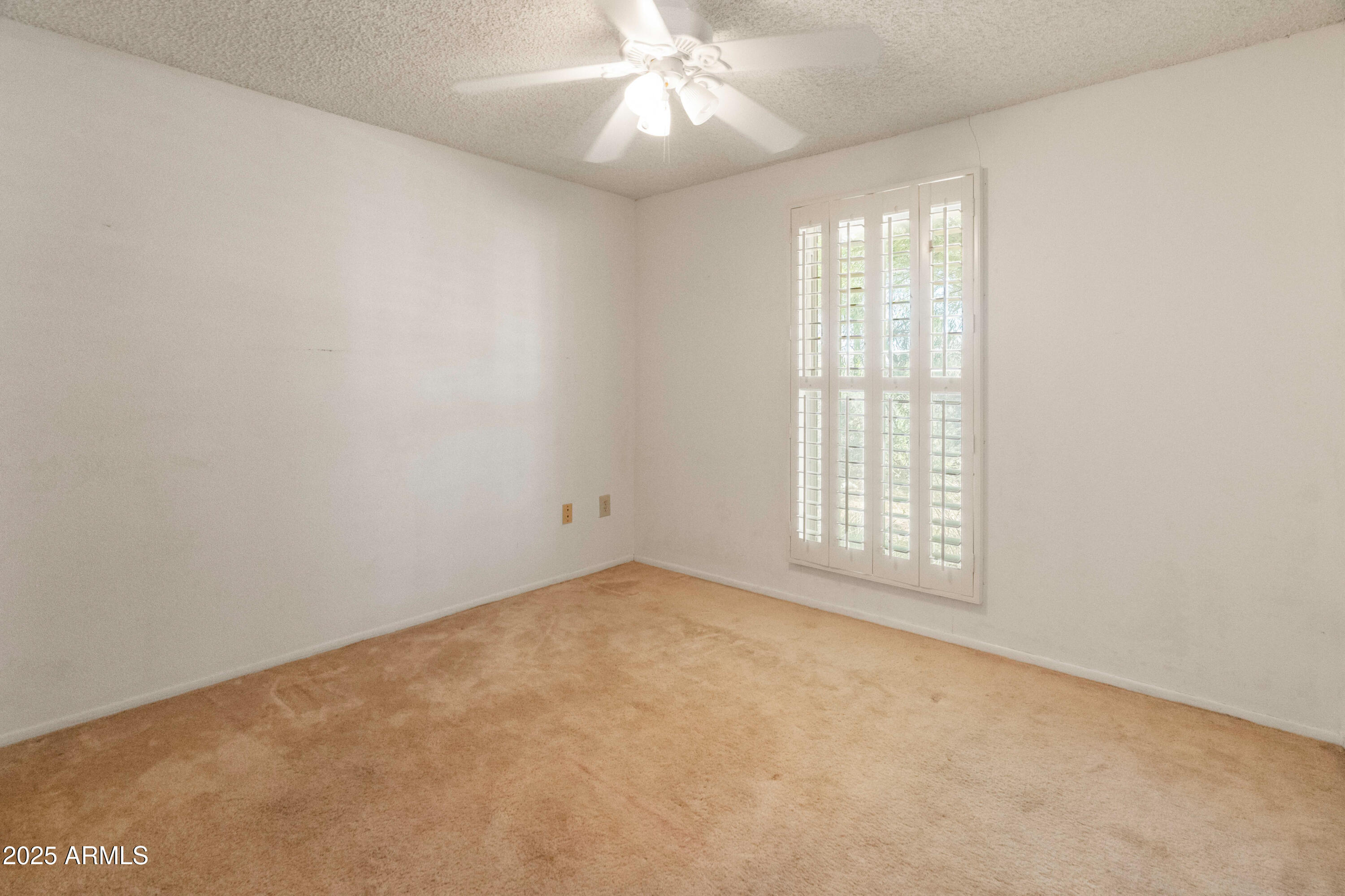 5506 West Hatcher Road Glendale, AZ 85302 - Photo 13 of 23 an empty room with a chandelier fan and windows