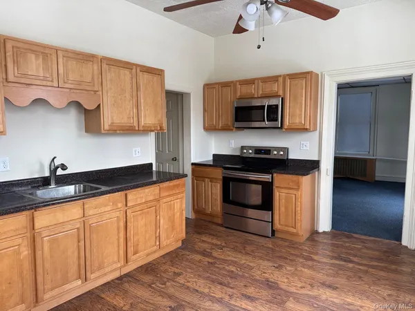 a kitchen with granite countertop a sink and a stove top oven
