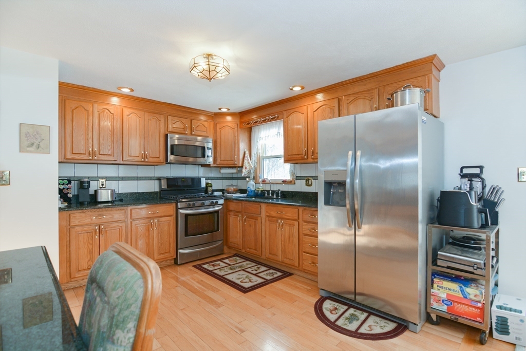 51 Heritage Road Billerica, MA 01821 - Photo 6 of 32 a kitchen with stainless steel appliances granite countertop a refrigerator a stove a sink and a microwave