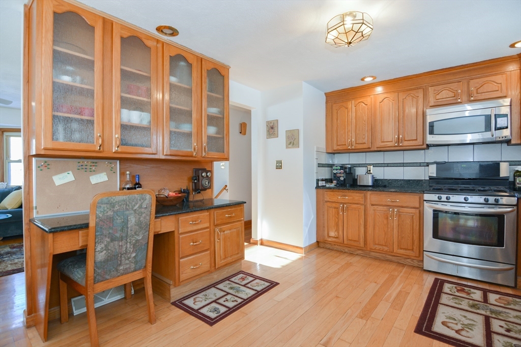 51 Heritage Road Billerica, MA 01821 - Photo 7 of 32 a kitchen with stainless steel appliances granite countertop a stove a sink and a refrigerator