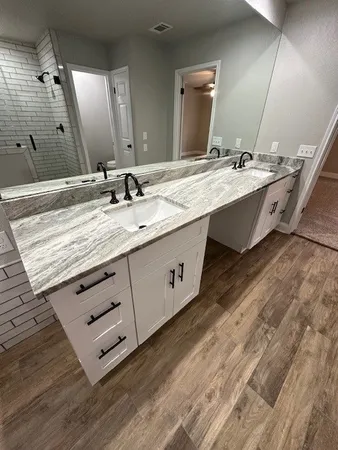a bathroom with double vanity sink and a mirror