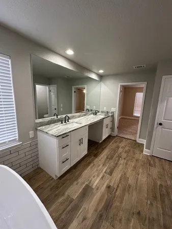 a large white kitchen with a sink dishwasher stove and cabinets