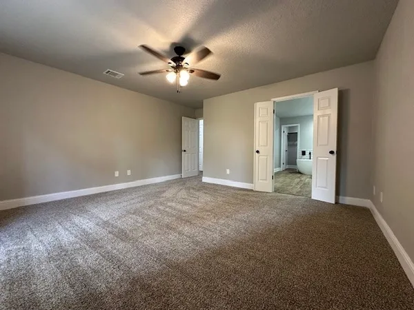 an empty room with closet and a chandelier fan