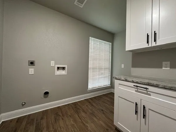 a view of empty room with window and wooden floor