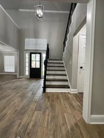 a view of a livingroom with wooden floor and stairs