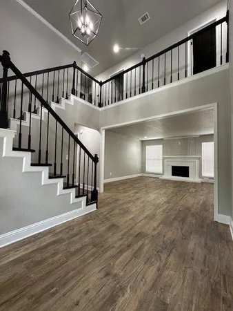 a view of staircase and living room with wooden floor