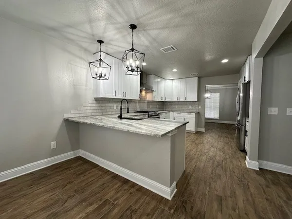 a view of a kitchen counter space a sink and wooden floor