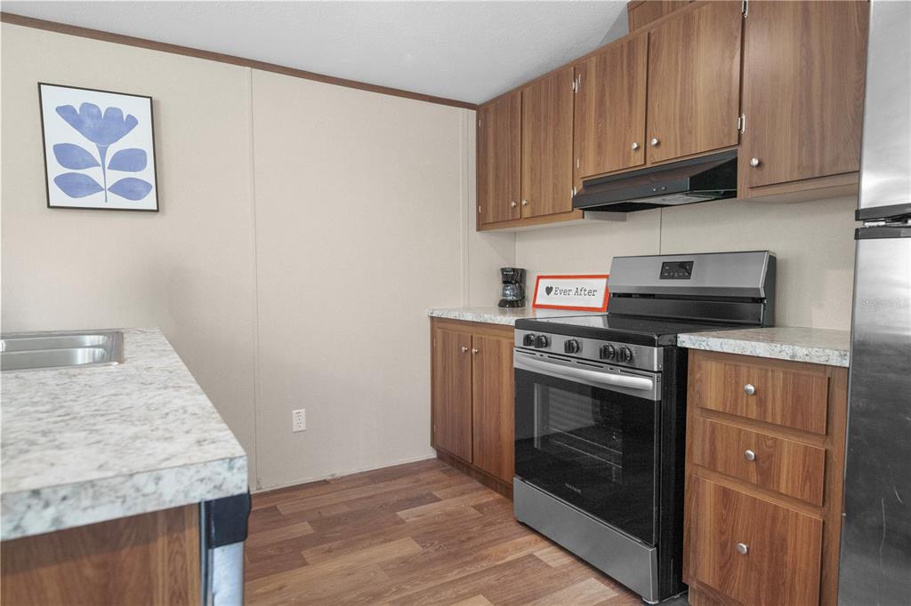 16770 Southwest 60th Place Ocala, FL 34481 - Photo 15 of 26 a kitchen with granite countertop cabinets stainless steel appliances and a wooden floor