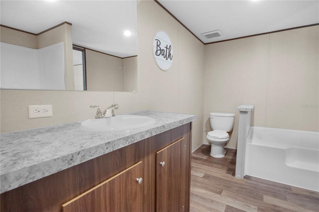 16770 Southwest 60th Place Ocala, FL 34481 - Photo 18 of 26 a bathroom with a granite countertop sink a toilet and a mirror