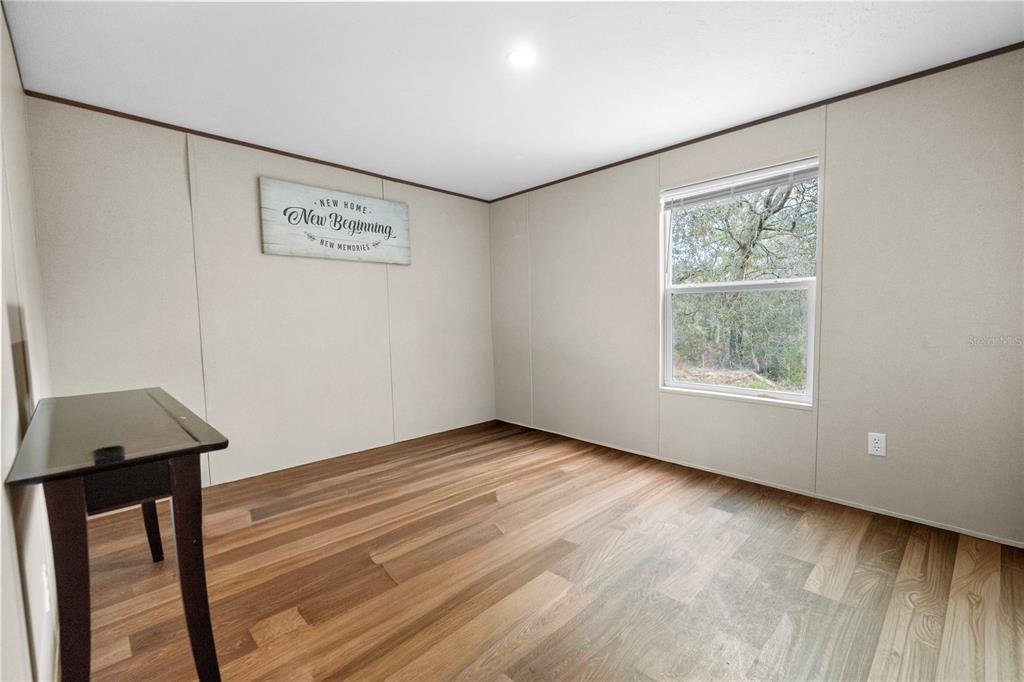 16770 Southwest 60th Place Ocala, FL 34481 - Photo 22 of 26 a view of an empty room with wooden floor and a window