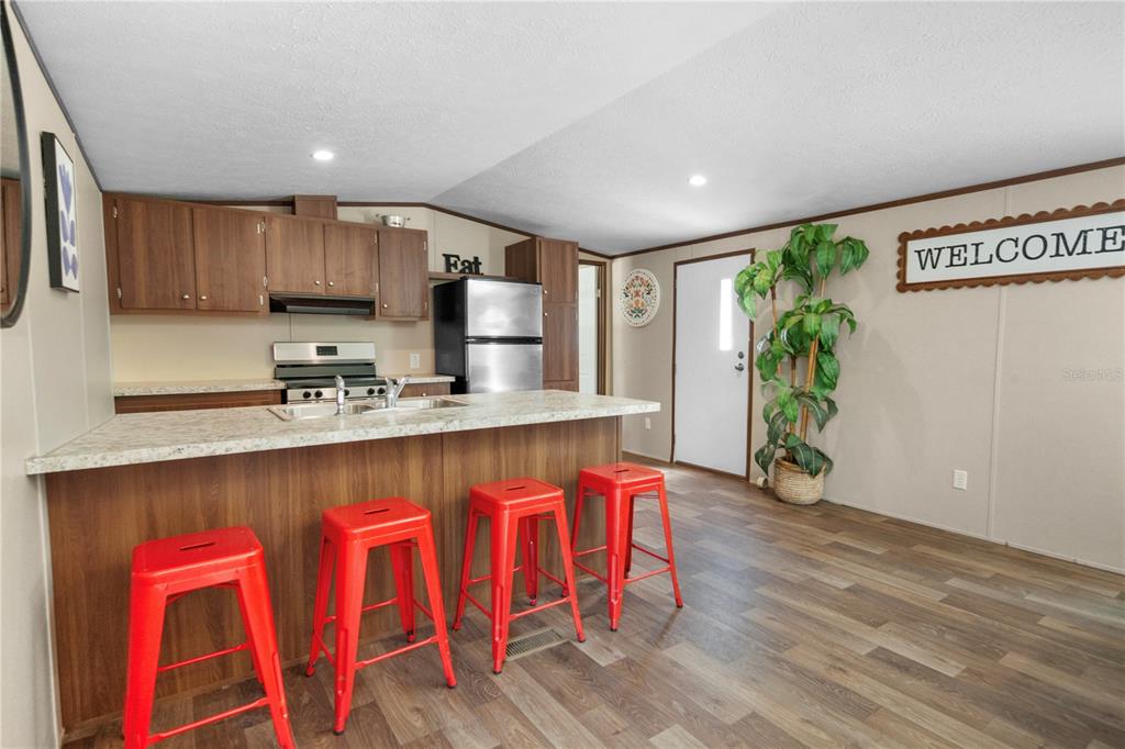 16770 Southwest 60th Place Ocala, FL 34481 - Photo 10 of 26 a kitchen with stainless steel appliances granite countertop a white cabinets and wooden floor