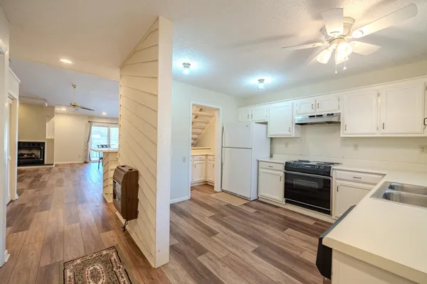 a kitchen with refrigerator cabinets and wooden floor