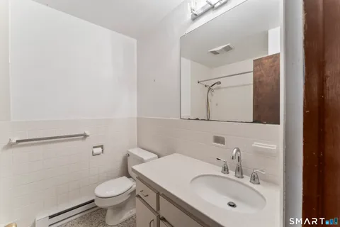 a bathroom with a sink toilet and mirror