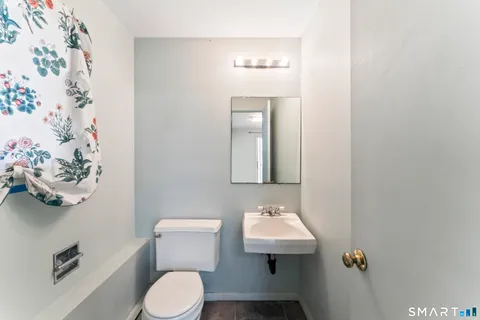 a bathroom with a toilet sink and mirror