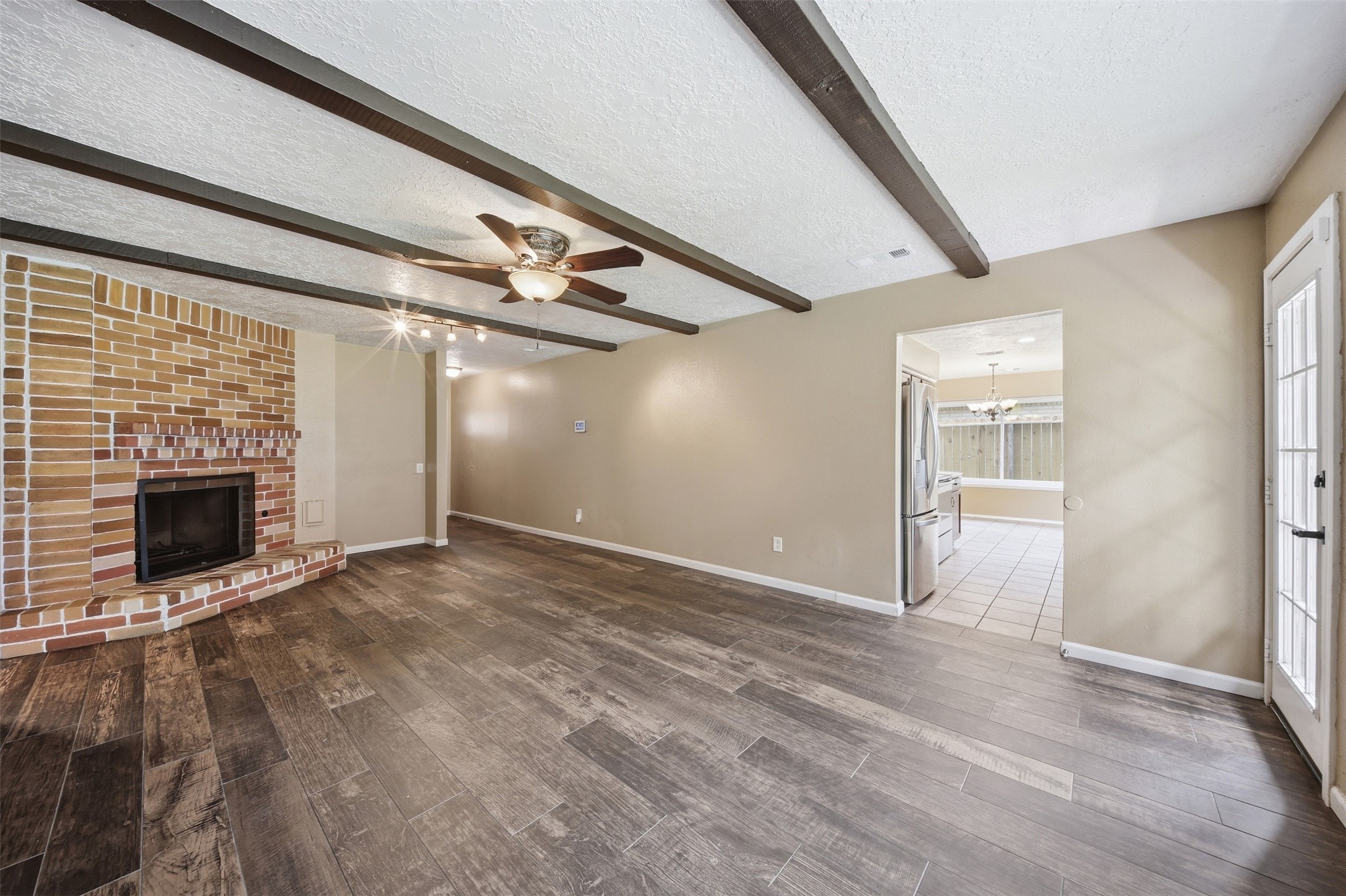 9418 Kilrenny Drive Spring, TX 77379 - Photo 18 of 47 a view of an empty room with wooden floor fireplace and a window