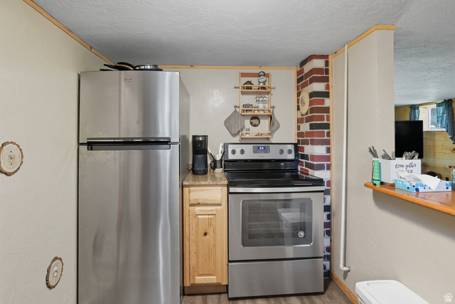 667 North Rapid Creek Road Inkom, ID 83245 - Photo 13 of 29 Kitchen area featuring stainless steel appliances, including a top-freezer refrigerator and a range with a black cooktop