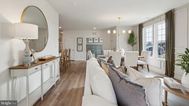 a living room with furniture a large window and wooden floors