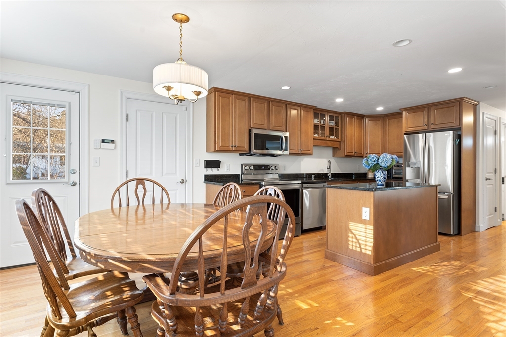 3 Fieldstone Circle, Unit 3 Wareham, MA 02576 - Photo 5 of 25 a kitchen with stainless steel appliances granite countertop a stove a refrigerator a kitchen island a dining table and chairs