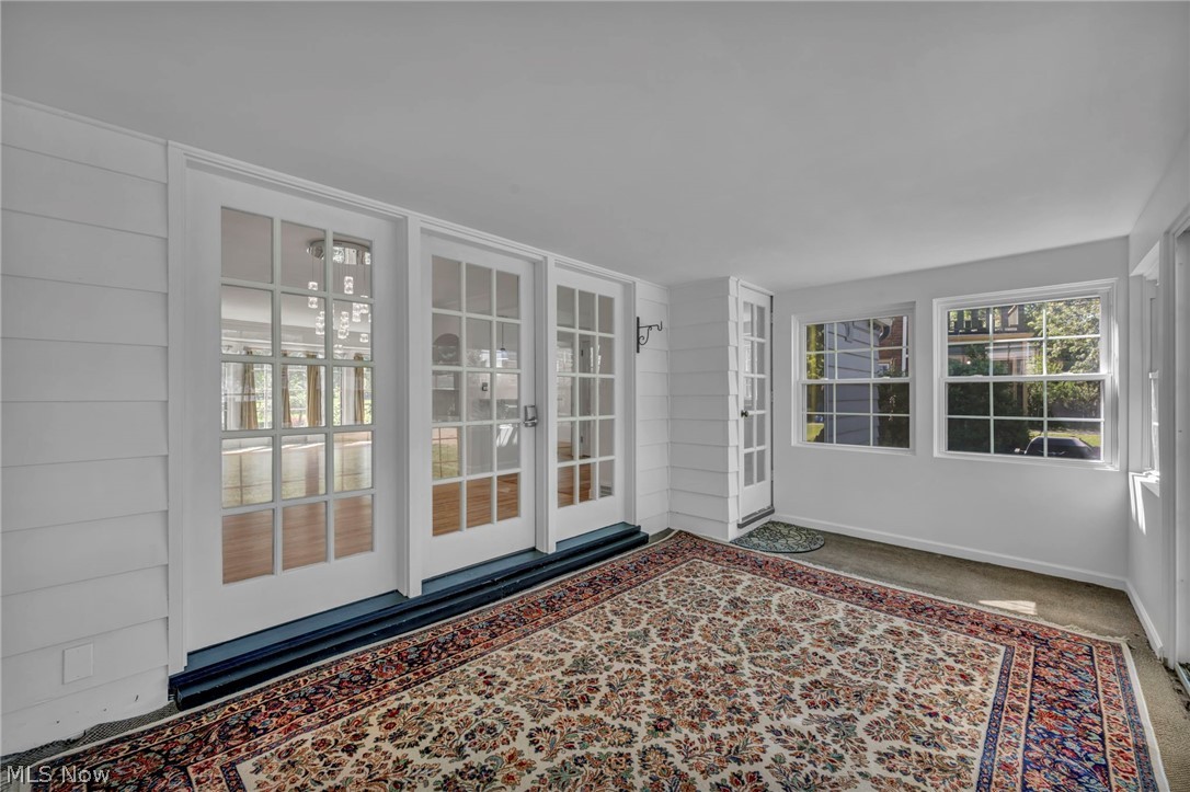 3543 Lytle Road Shaker Heights, OH 44122 - Photo 39 of 49 Sun-drenched interior space featuring multiple windows, a white paneled wall, and a series of glass-paned doors