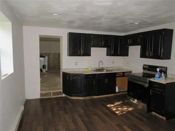a kitchen with granite countertop a stove and cabinets
