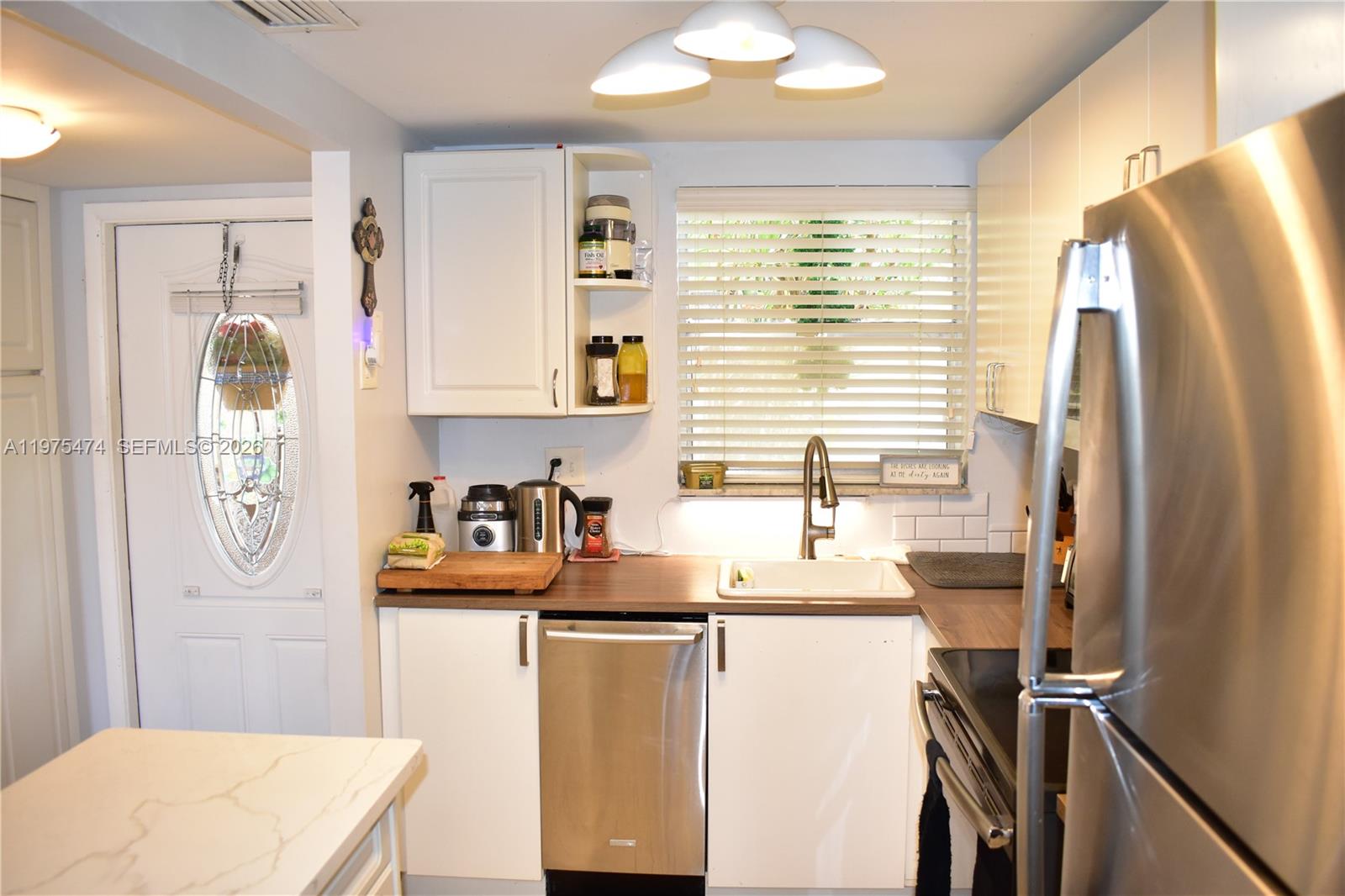 2801 North Pine Island Road, Unit 112 Sunrise, FL 33322 - Photo 12 of 49 a kitchen with refrigerator and window