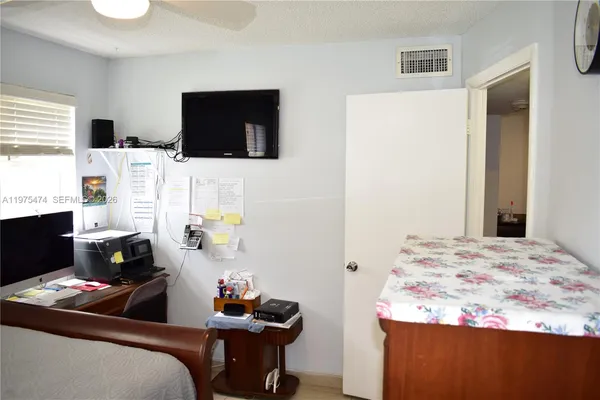 a bedroom with a bed and a computer on a table