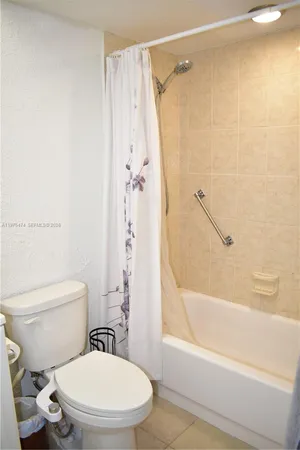 a white toilet and shower sitting next to a bathroom sink
