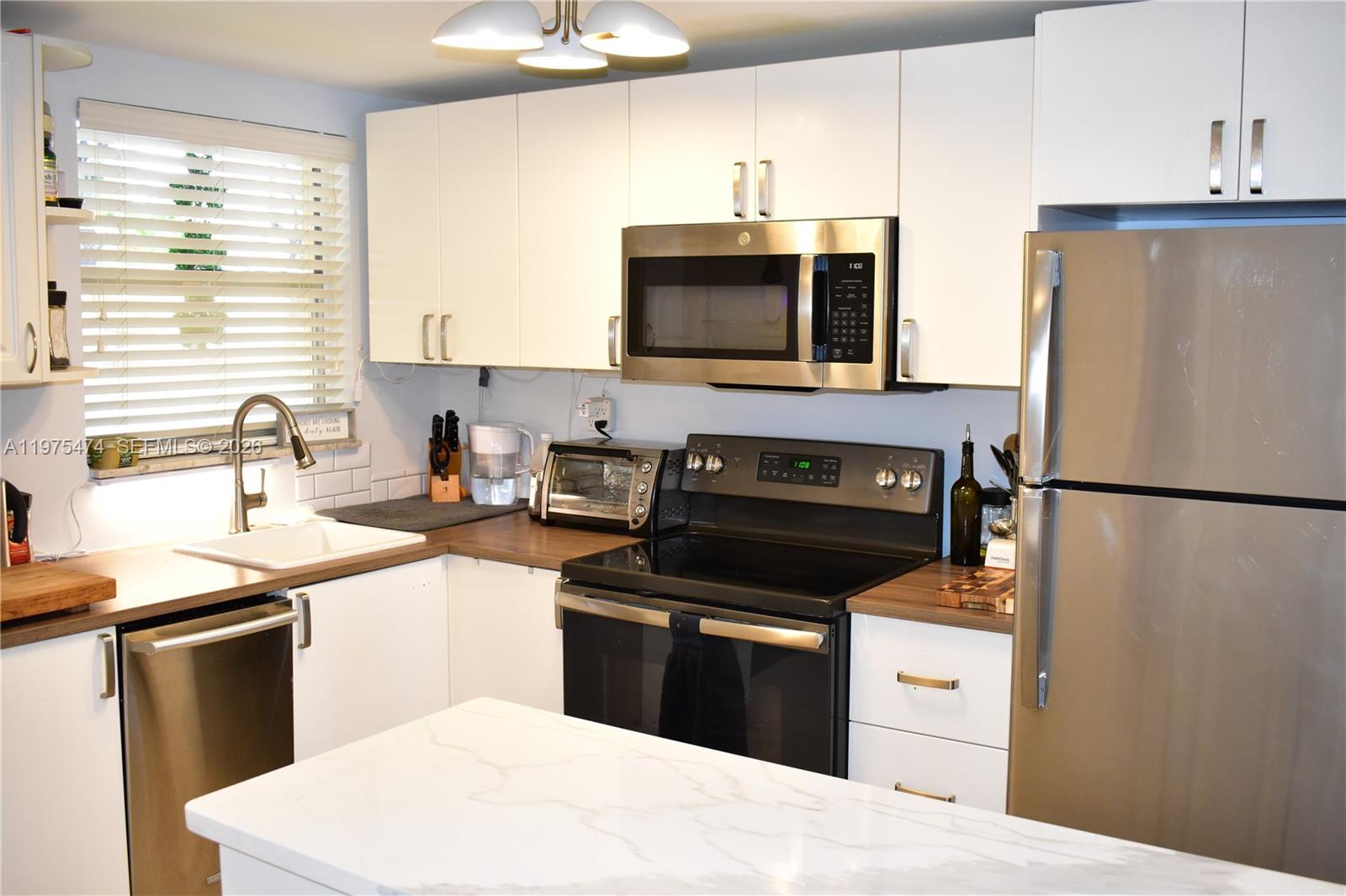 2801 North Pine Island Road, Unit 112 Sunrise, FL 33322 - Photo 8 of 49 a kitchen with a sink stove and refrigerator