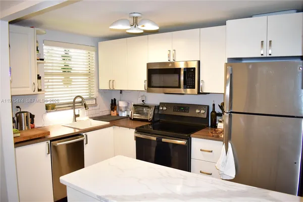 a kitchen with stainless steel appliances a refrigerator stove and microwave