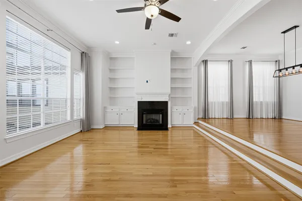 a view of empty room with wooden floor and fireplace
