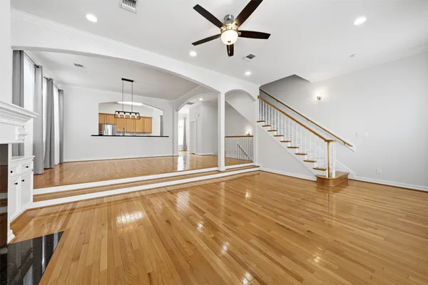 a view of an empty room with window and wooden floor