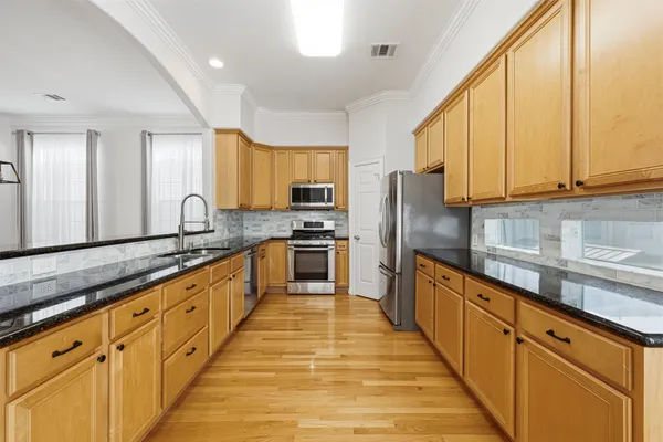 a large kitchen with stainless steel appliances granite countertop a stove a sink dishwasher and a refrigerator