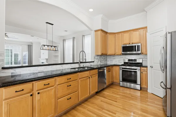 a kitchen with granite countertop a stove a sink and a microwave