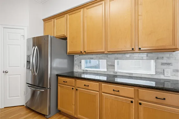 a kitchen with stainless steel appliances granite countertop a refrigerator and a sink