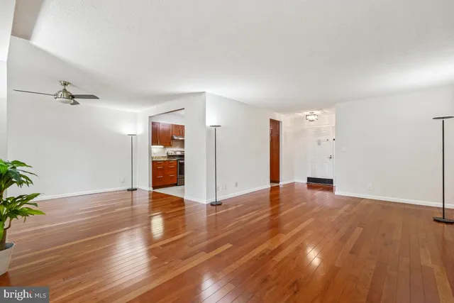 a view of a room with wooden floor staircase and a kitchen space