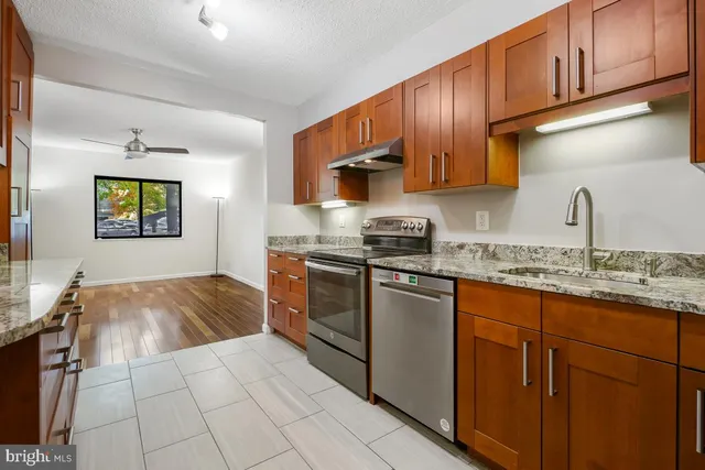 a view of a hallway to a livingroom with wooden floor and furniture