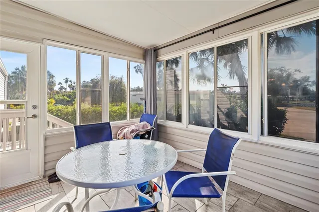 a dining room with furniture large windows and wooden floor