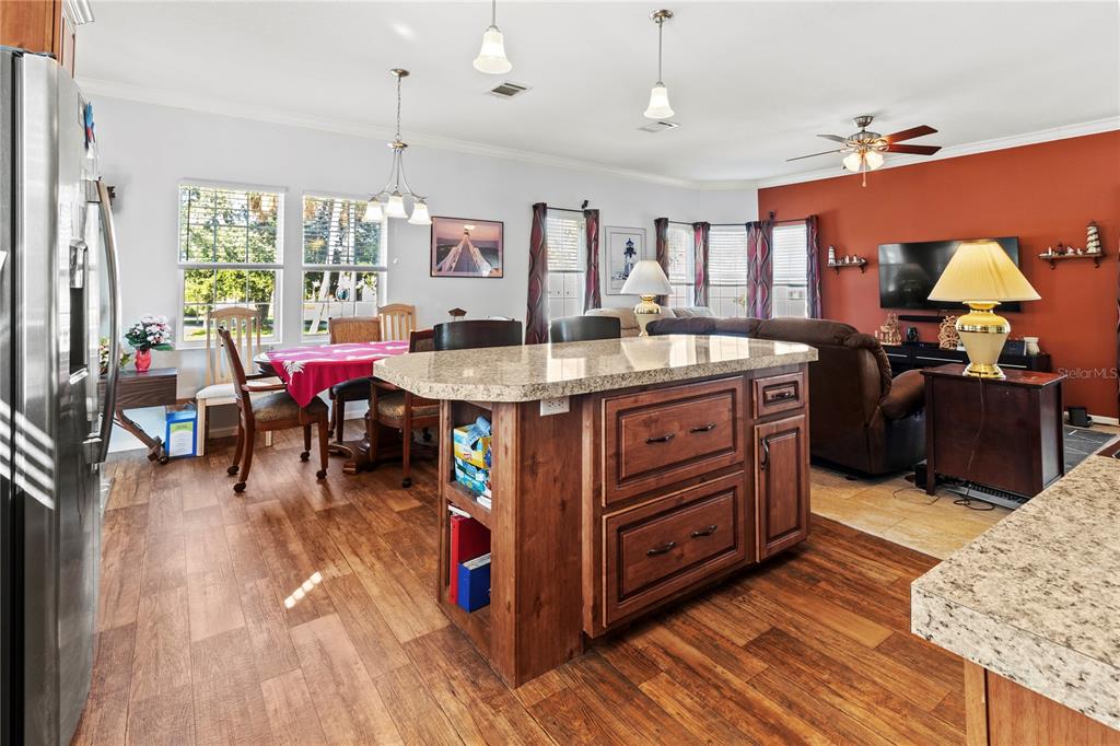1 Meadow Circle Ellenton, FL 34222 - Photo 10 of 52 a view of a kitchen with kitchen island stainless steel appliances a stove center island a dining table and chairs