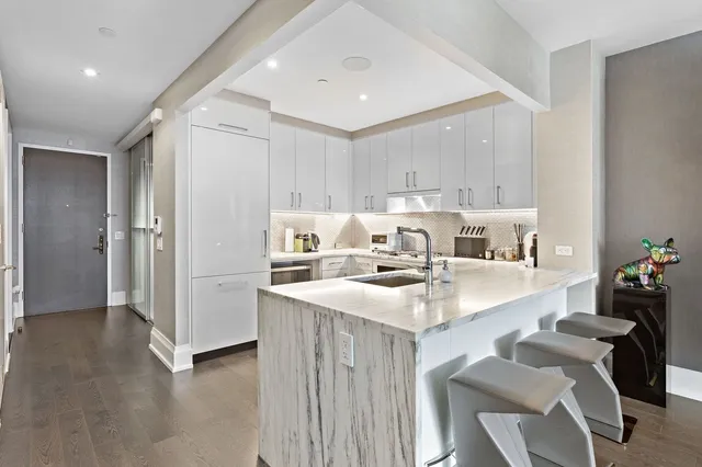a kitchen with a sink cabinets and chairs