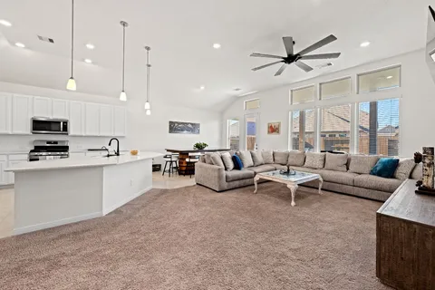 a living room with furniture and a view of kitchen